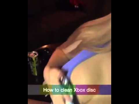 Девушка показывает, как очистить диск Xbox перед использованием