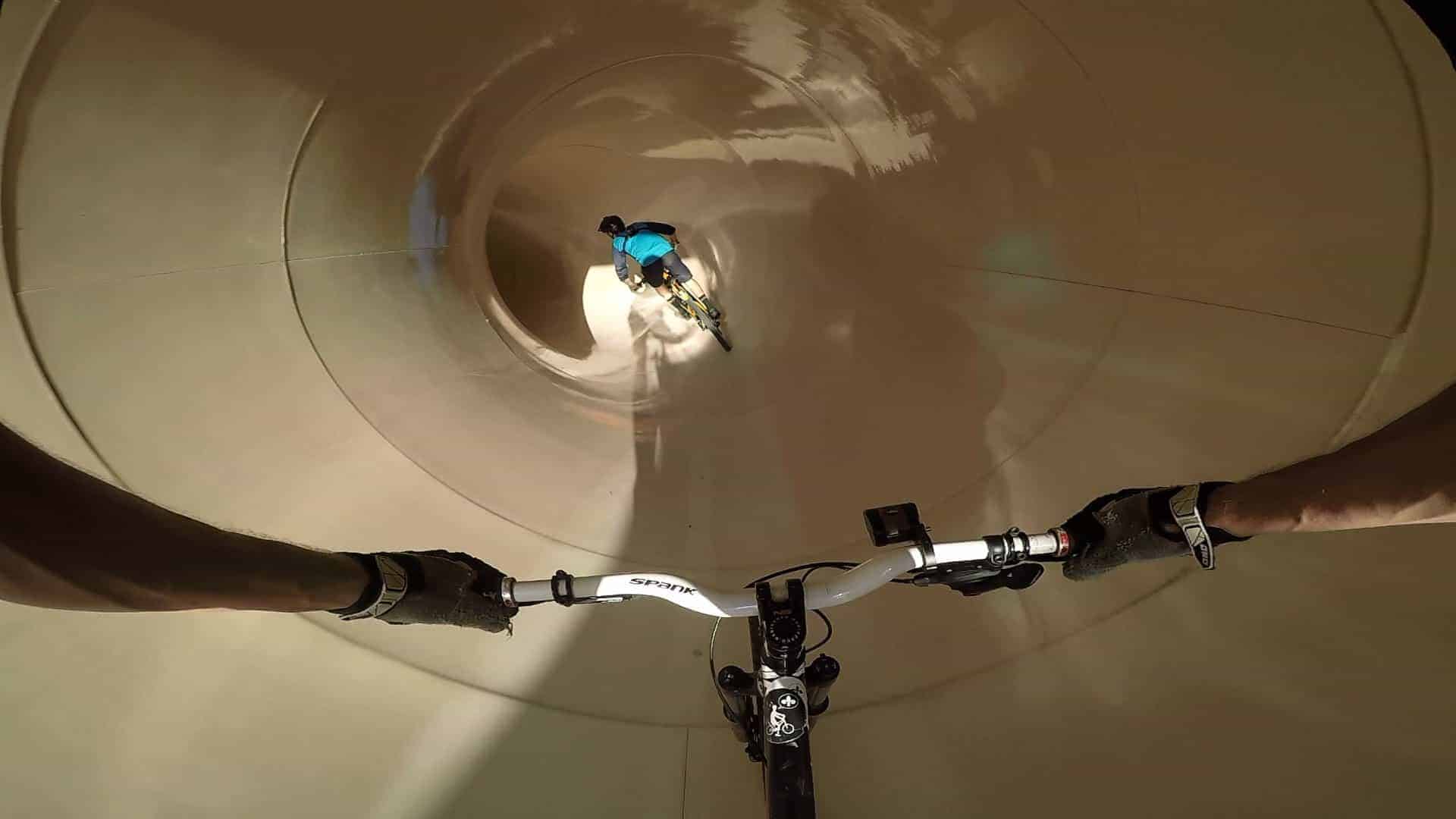 Down the water slide on a mountain bike from a first-person perspective