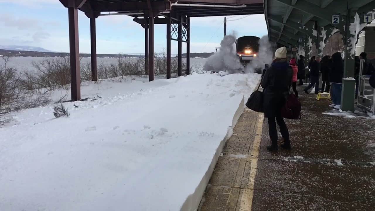Wenn ein Zug in Slow Motion auf verschneitem Gleis durch einen Bahnhof rast
