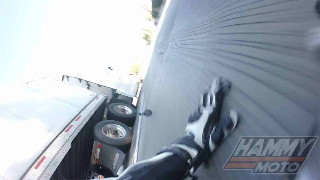 Motocyklista spadne a skĺzne pod idúci kamión