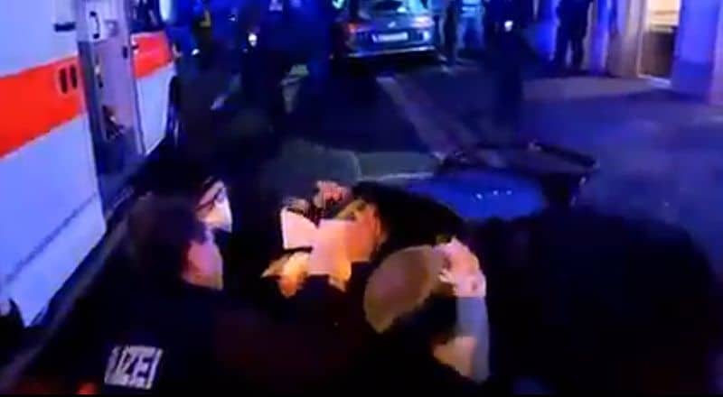 Polizisten spritzen ein Baby im Kinderwagen mit Pfefferspray voll